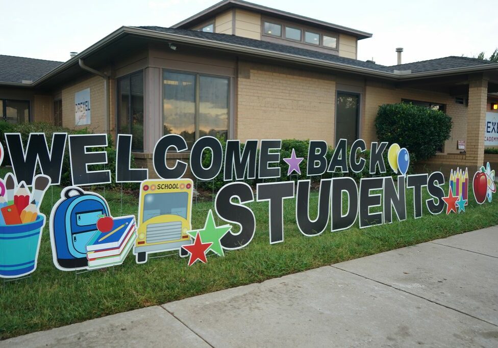 welcome back students sign in front of school