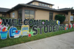 welcome back students sign in front of school